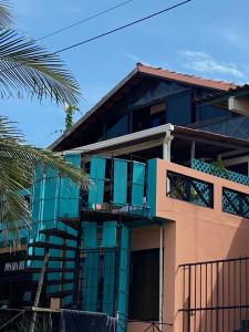 拉斯塔布拉斯Uverito Sand Dollar B&B的一座拥有蓝色窗户和棕榈树的建筑