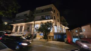 耶路撒冷תבל PRIVATE HOTEL的一座建筑,晚上停在前面