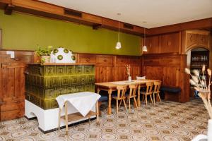 上德劳堡Boutiquehotel Lindenhof的一间设有桌子和绿色墙壁的用餐室