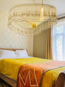 坎帕拉Keitylin Heights Apartments in Makindye的一间卧室配有一张黄色的吊灯