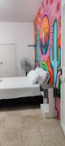 洛佩斯港Garden House Puerto López的一间卧室设有一张床和色彩缤纷的墙壁