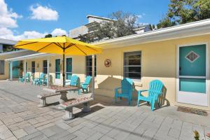 克利尔沃特Pelican Beach Studio #6的庭院配有桌椅和遮阳伞。