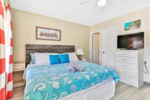 克利尔沃特Pelican Beach Studio #6的一间卧室设有一张大床和电视
