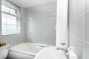 HanwellSpacious en-suite in a 5-Bedroom House at Hanwell (2nd Floor)的带浴缸、卫生间和盥洗盆的浴室