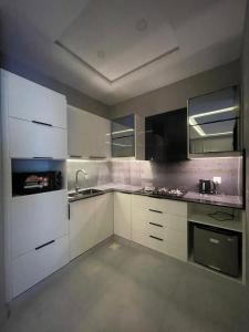 伊斯兰堡Villa Vista的厨房配有白色橱柜和炉灶烤箱。