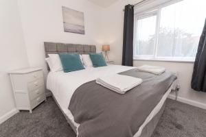 哈特尔普尔Jesmond Square的卧室设有一张白色大床和一扇窗户。