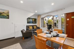 陶波Taupo Central Apartment的用餐室以及带桌椅的起居室。