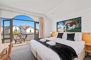 陶波Taupo Central Apartment的一间带大床的卧室和一个阳台