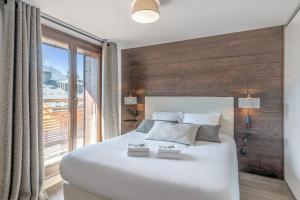 代米考迪亚Appartement Geneva - Welkeys的卧室设有一张大白色的床和大窗户