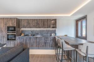 代米考迪亚Appartement Geneva - Welkeys的厨房配有木制橱柜和木桌。
