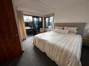 北哈夫洛克Woolshed 17 - Self Catering Accommodation的一间卧室设有一张大床和一个滑动玻璃门