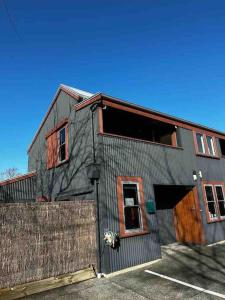 北哈夫洛克Woolshed 17 - Self Catering Accommodation的灰色的建筑,设有木门和栅栏