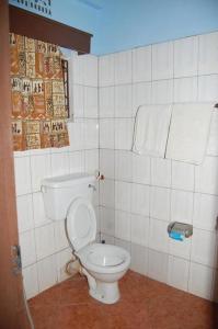 阿鲁沙Swahili House & Art的浴室设有白色卫生间,位于瓷砖墙壁上