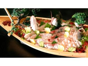 鹤冈市Yunohama Onsen Hanayubi Nihonkai - Vacation STAY 67567v的桌上一盘带海鲜的食品