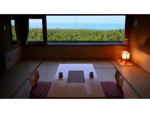 鹤冈市Yunohama Onsen Hanayubi Nihonkai - Vacation STAY 67567v的客房设有桌子和大窗户。