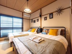 大阪Chachamaru Osaka Castle Park - Vacation STAY 15422的一间卧室设有两张床,墙上挂着一个时钟。