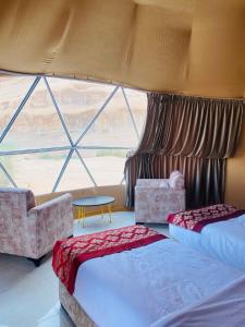 瓦迪拉姆Syndebad desert camp的一间卧室设有两张床和大窗户