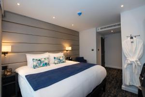 伦敦Signature London, The J Marylebone的酒店客房配有一张带蓝白色枕头的大床