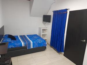 卡利apartaestudios el jardin 2的一间卧室配有床和蓝色窗帘