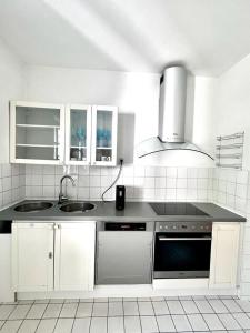 Green House bei Baden的白色的厨房设有水槽和炉灶。