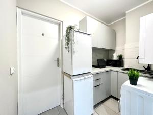 格但斯克MMRent Ocean Room的厨房配有白色橱柜和冰箱。