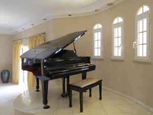 波尔蒂芒Villa Moments - Guest House的椅子房间里黑钢琴