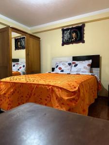 库斯科Hospedaje Qorichaska's的一间卧室配有一张带橙色床罩的床