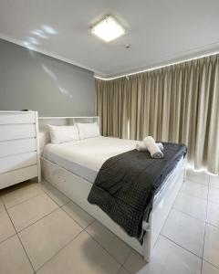 黄金海岸拜伦内公寓的卧室配有白色的床和窗户。
