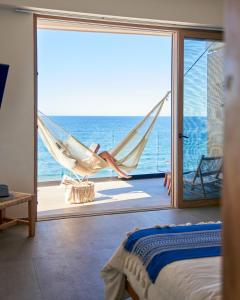 蓬塔米塔Hotel Basalto的一间带吊床的卧室,享有海景