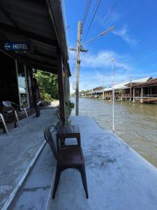 RatchaburiReuan Vilawan的坐在河边码头上的长凳