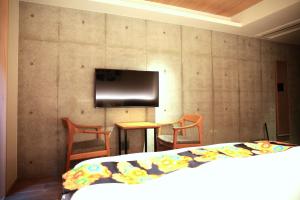 京都Hotel Legasta Kyoto Higashiyama Sanjo的一间卧室配有一张床,墙上配有电视