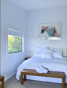LowtherThe View @ Ulandi的一间卧室设有蓝色的墙壁和一张带长凳的床
