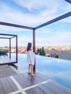 Pekayon SatuGrand Kamala Lagoon Bekasi Apartement的站在甲板上看游泳池的女人