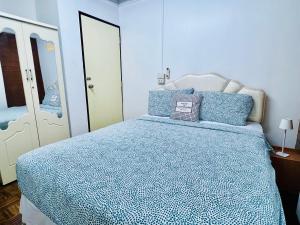 曼谷Ree Guesthouse的一间卧室配有一张带蓝色棉被的床