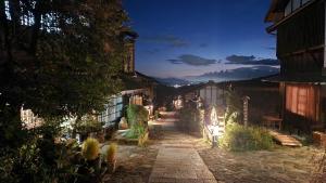 中津川市GUESTHOUSE YANAGIYA的夜晚有灯光的房子的庭院