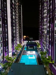 艾尔克如Melaka Farzana Homestay的两个高楼中间的一个游泳池