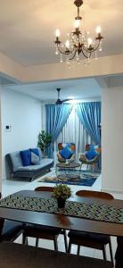 艾尔克如Melaka Farzana Homestay的客厅配有桌子和蓝色窗帘