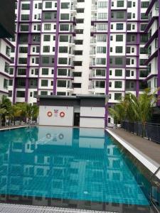 艾尔克如Melaka Farzana Homestay的一座高楼前的大型游泳池