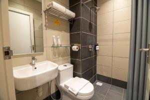 新山Fives Hotel Meldrum的一间带水槽、卫生间和镜子的浴室