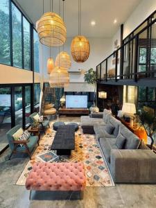 峇冬加里The Estate Hulu Rening - Private Retreat Cabin的带沙发、桌子和窗户的大型客厅