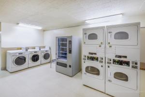 拉雷多Super 8 by Wyndham Laredo的洗衣房配有3台洗衣机和烘干机