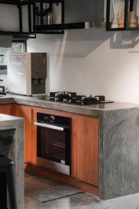 峇冬加里The Estate Hulu Rening - Private Retreat Cabin的厨房配有炉灶和微波炉