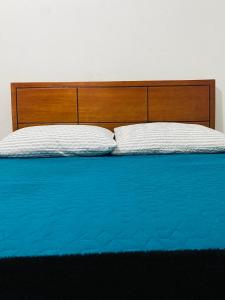 波哥大Bogotá Kings 101的一张带木制床头板的床和两个枕头