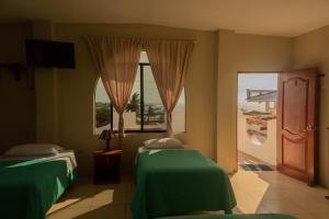 巴克里索莫雷诺港Casa de Nelly的酒店客房设有两张床和窗户。