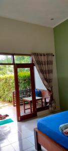 沙璜全景塞拉库住宿加早餐旅馆的卧室设有滑动玻璃门和阳台