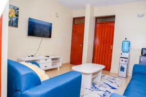 基苏木SYLVIA'S LUXURIOUS APARTMENT的客厅设有蓝色的沙发和红色的门