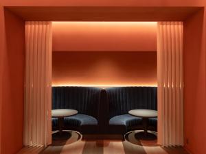 福冈Hotel Il Palazzo的一间酒吧,配有蓝色座椅和两张桌子