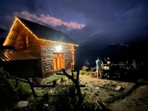 吉布Nebula Nook Cottages的夜间站在木屋外的人
