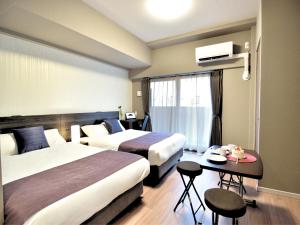 大阪BON Condominium Namba Ebisu的酒店客房设有两张床和一张桌子。