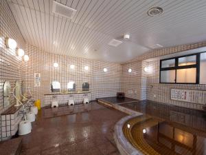 甲府Tabist Hotel Yamashiro Onsen的大型浴室设有水槽和卫生间。